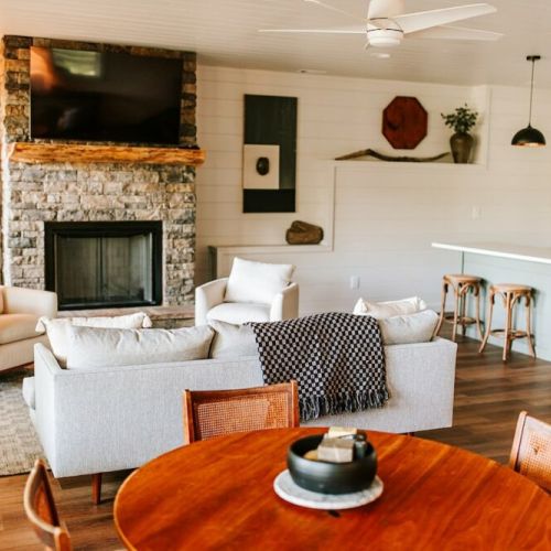 The lower-level lounge is a bright and airy space with a large wall of windows that provide similar views to those upstairs. There’s also a gas fireplace, a big-screen TV, wet bar, and an heirloom game table with a small collection of fun games.