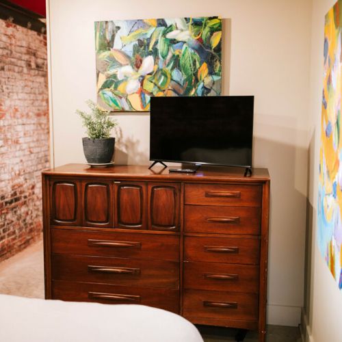 This bedroom features a dresser and television complete with cable tv.