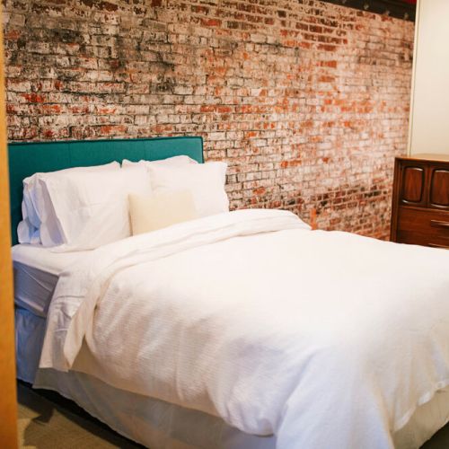 Each bedroom boasts comfortable queen sized mattresses with organic cotton linens. This bedroom is open to the  main living space with partial privacy provided by a partition.