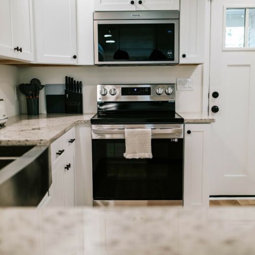 The newly renovated kitchen features modern, stainless steel appliances and bright white cabinets.