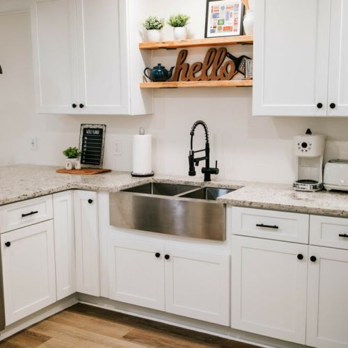 The newly renovated kitchen features a stainless steel apron front sink and stainless steel appliances.