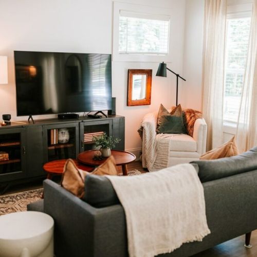 The stylish living room features a comfy sofa, a large HDTV with premium cable, a record player, and an assortment of books, making it the perfect room to gather with your group and enjoy some quality time together.