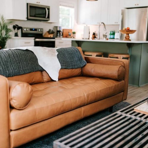 The stylish living room features a comfy sofa, a large HDTV with premium cable, a record player, and an assortment of books, making it the perfect room to gather with your group and enjoy some quality time together.
