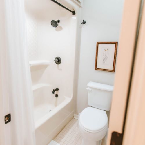 Simple and spotless, this full bathroom offers a clean, cozy space to refresh and reset, complete with modern matte black fixtures and thoughtful touches.