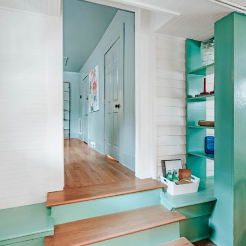 Move easily between the dining area and living spaces through this character-filled interior, where original details, warm wood floors, built-in shelving, and vibrant color create a welcoming flow for your stay.