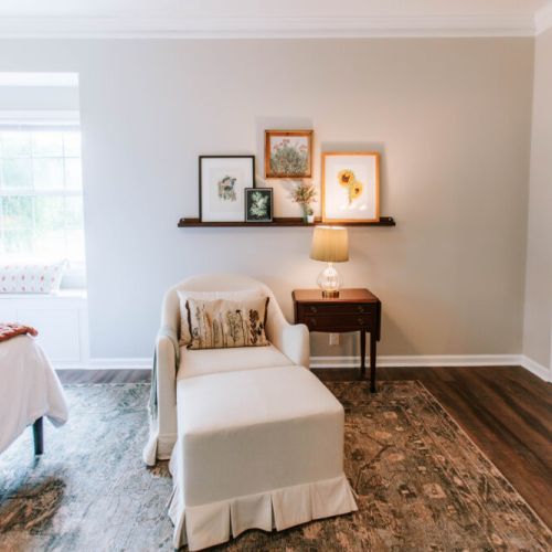 Unwind in this serene bedroom retreat featuring a cozy reading nook, charming picture ledge gallery, and a sunlit window seat perfect for slow mornings or quiet evenings.