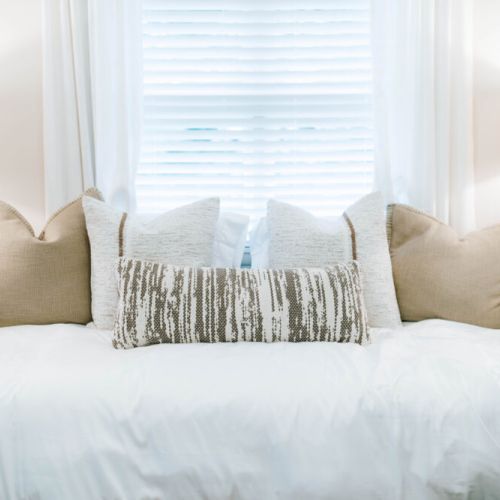 Bright, fresh, and inviting — this sunlit bed with layers of soft pillows creates the perfect spot to relax, recharge, or enjoy a peaceful morning.