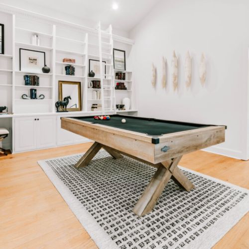 Spacious game room with a pool table and shelves -  perfect for fun game nights with family and friends.