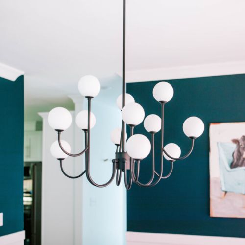 Dine under a modern chandelier with a side of personality—where bold style meets playful art in every corner.