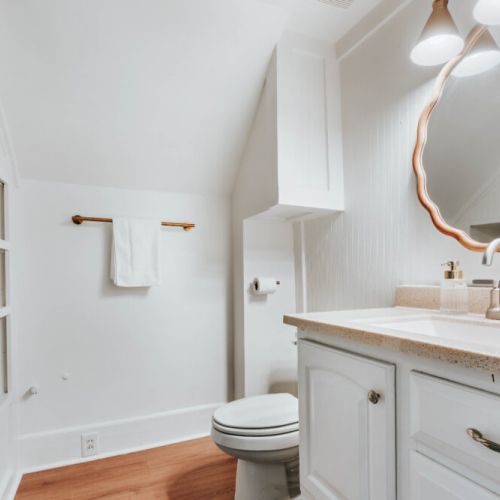 Refresh and recharge in this bright, thoughtfully designed bathroom featuring a walk-in shower, spacious vanity, and warm wood floors. A clean, comfortable space with everything you need to get ready for the day or wind down in the evening.
