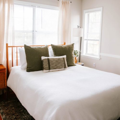 Wake up refreshed in this sunlit retreat, where soft linens, earthy tones, and cozy textures invite you to slow down and settle in.