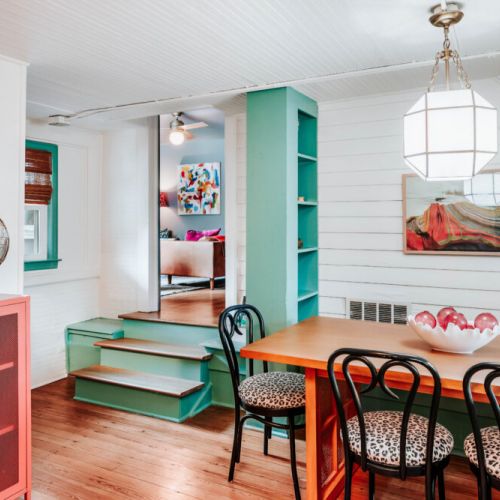 Gather around the colorful dining space for morning coffee, shared meals, or evening conversation. With warm wood floors, vibrant décor, comfortable seating, and a Keurig nearby, it’s an inviting spot to connect and enjoy your stay.