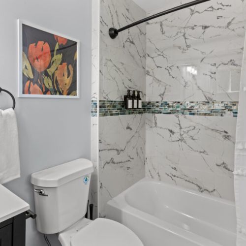 Unwind in a chic tub surrounded by elegant marble tile and artistic flair—your perfect retreat after a day of adventure!