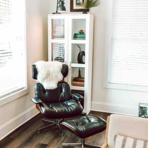 Unwind in style: this comfy chair and reading corner in the living room beckon you to relax with your favorite book, creating a cozy retreat within your home.