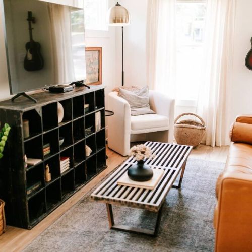 The stylish living room features a comfy sofa, a large HDTV with premium cable, a record player, and an assortment of books, making it the perfect room to gather with your group and enjoy some quality time together.