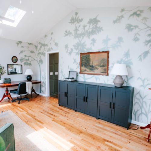 Sunlight, soft chairs, and a little music set the mood in this little home office area.