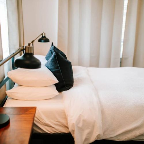 Cozy comfort awaits: this bedroom is furnished with soft pillows, promising a restful night's sleep in a warm and inviting setting.
