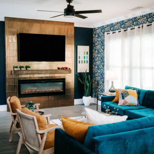 Snuggle up by the sleek electric fireplace, sink into plush velvet sofas, and soak in the natural light dancing off bold, vibrant décor. Whether you're binge-watching on the big screen or sipping wine under soft-glow lighting, this living room is the perfect vibe for your getaway.