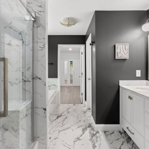 Step into this spa-inspired bathroom featuring sleek marble floors, dual vanities, and a walk-in shower that redefines relaxation.