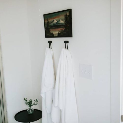 Unwind in comfort: this bathroom features convenient hooks for guests to hang their towels, adding a touch of ease to their stay.