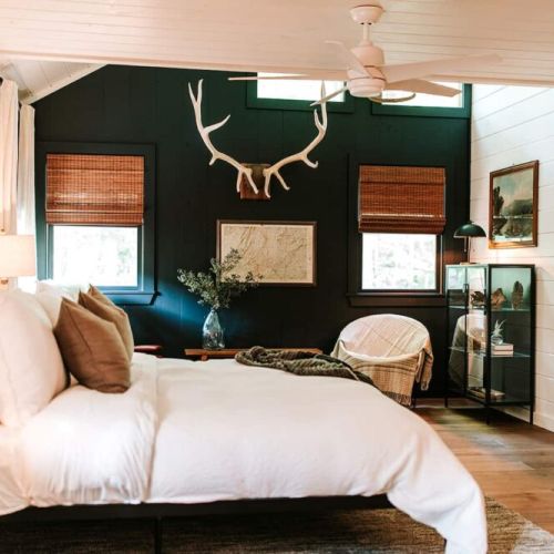 Primary Bedroom on Main Level. Each of the cabin’s four bedrooms is designed with guest comfort in mind. Fall asleep beneath luxurious linens and wake up refreshed for another exciting (or relaxing!) day in the mountains.