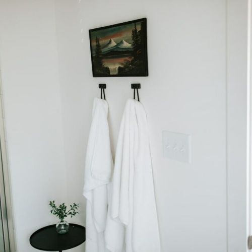 Unwind in comfort: this bathroom features convenient hooks for guests to hang their towels, adding a touch of ease to their stay.