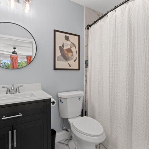 This stylish full bathroom features modern touches, a shower, and a touch of art—perfect for a refreshing start or a relaxing wind-down.