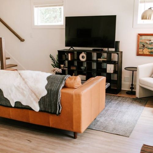 The stylish living room features a comfy sofa, a large HDTV with premium cable, a record player, and an assortment of books, making it the perfect room to gather with your group and enjoy some quality time together.