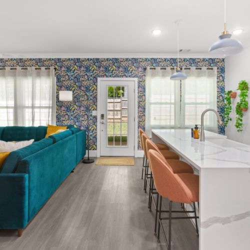 Start your mornings at the chic marble island and bask in natural light surrounded by bold wallpaper, cozy seating, and vibrant vibes.