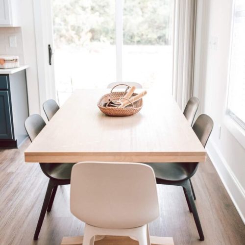 The kitchen opens up onto the sleek dining area. You’ll find a charming wooden dining table that comfortably seats six. You’ll love the clean lines, high ceilings, as well as new furniture to elevate your dining experience.