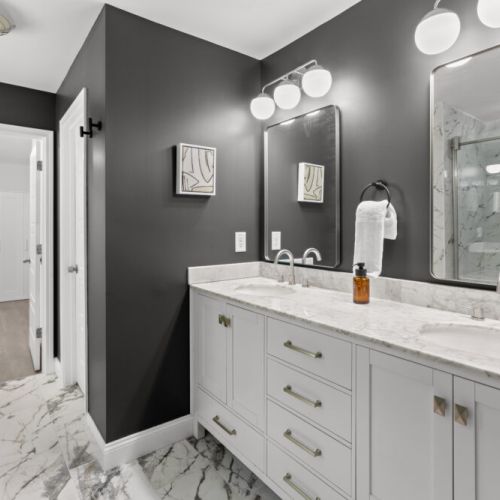Step into this spa-inspired bathroom featuring sleek marble floors, dual vanities, and a walk-in shower that redefines relaxation.