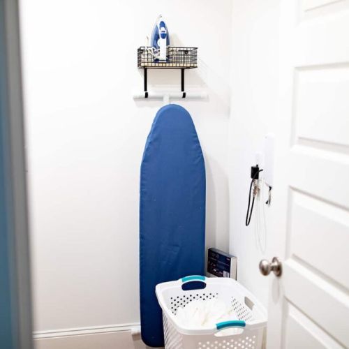 Laundry room fully equipped with detergent, steamer, iron and ironing board.