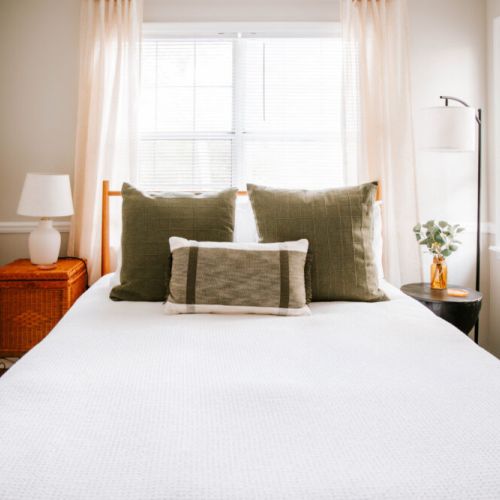 Wake up refreshed in this sunlit retreat, where soft linens, earthy tones, and cozy textures invite you to slow down and settle in.