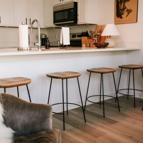 Pull up a seat at our elegantly curated dining area, where a sleek table harmonizes with chic barstool seating. Whether you're savoring a gourmet meal or enjoying a casual conversation over coffee, this inviting setup offers both style and comfort.