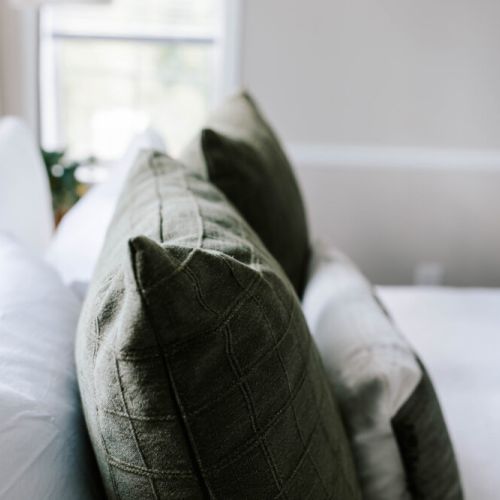 Layered linens and textured pillows create the perfect spot to sink into comfort—because every detail counts when you're ready to unwind.