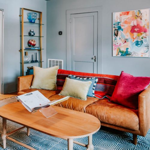 Kick back in this stylish living room, where a leather sofa, colorful accents, and vibrant artwork create an inviting place to relax. Flip through a book, catch up with friends, or simply unwind after a day of exploring.