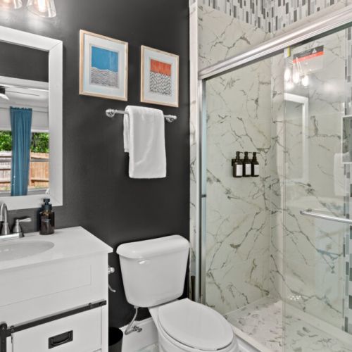 Step into style with this sleek, marble-accented bathroom—where bold design meets everyday luxury.
