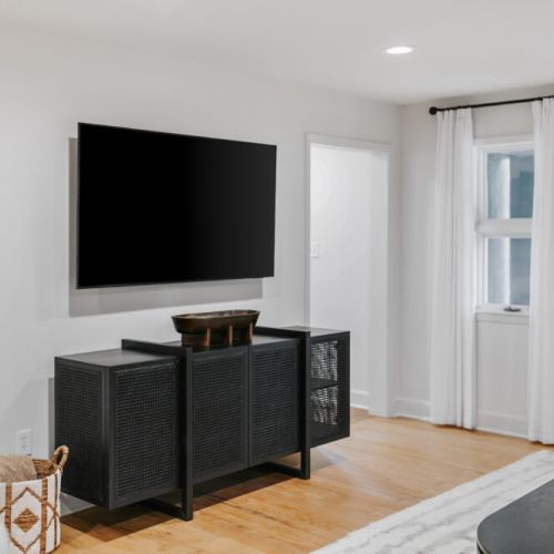 Cozy living area with a large flat-screen TV, ideal for relaxing and movie nights.