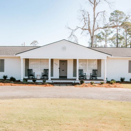 Bright, inviting home with classic porch seating and spacious yard.