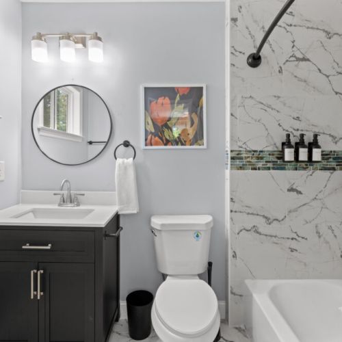 Unwind in a chic tub surrounded by elegant marble tile and artistic flair—your perfect retreat after a day of adventure!