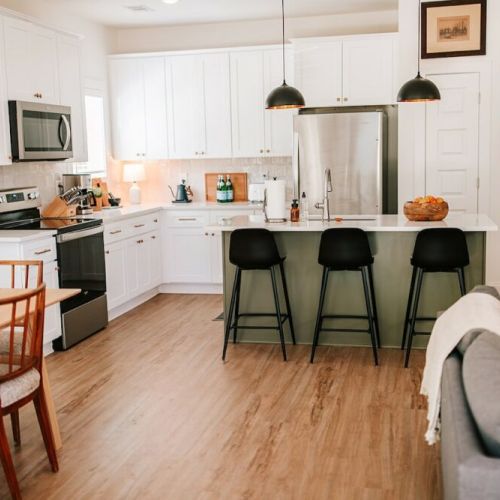 The luxurious kitchen is complete with stainless steel appliances and an island with seating for three, perfect for socializing with friends and family while creating delicious meals.