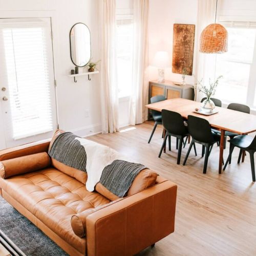 The stylish living room features a comfy sofa, a large HDTV with premium cable, a record player, and an assortment of books, making it the perfect room to gather with your group and enjoy some quality time together!