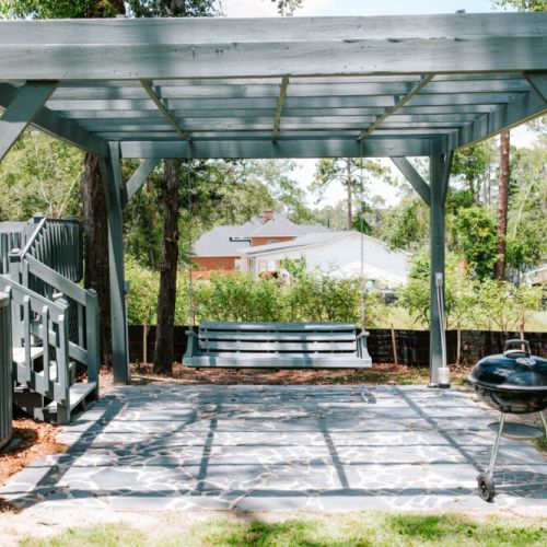 This shaded swing and grill patio is perfect for easy afternoons, good conversations, and southern skies.