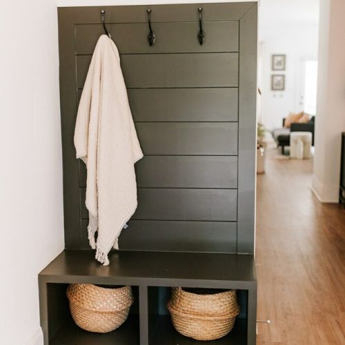 Organized and inviting: the rear entryway features two rattan baskets and hooks, providing a stylish and practical storage solution for coats and accessories.