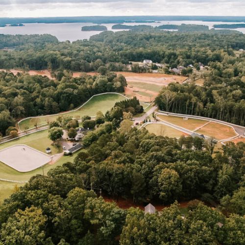 Aerial view of the neighborhood with Lake Lanier in the background, highlighting the home’s close proximity to the water.