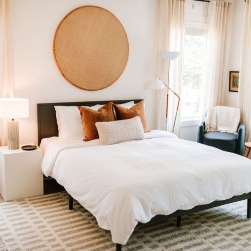 Primary bedroom with a queen-sized bed and en suite bathroom, complete with a Purple mattress and luxurious organic linens.