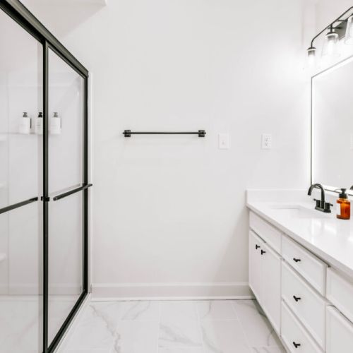 Refresh in a sleek, spa-inspired bathroom — featuring a glass walk-in shower, modern finishes, and bright lighting designed to make every moment feel indulgent.