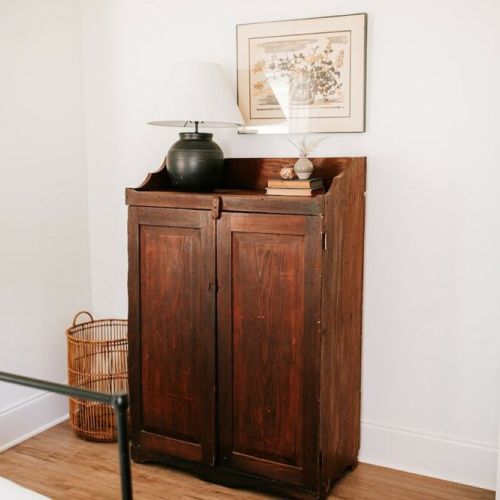 Rustic charm meets functionality: this room is accentuated by a charming rustic cabinet.