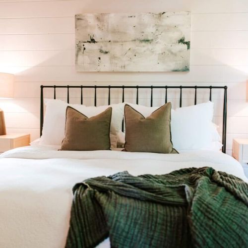 Primary bedroom on main level. Each of the cabin’s four bedrooms is designed with guest comfort in mind. Fall asleep beneath luxurious linens and wake up refreshed for another exciting (or relaxing!) day in the mountains.